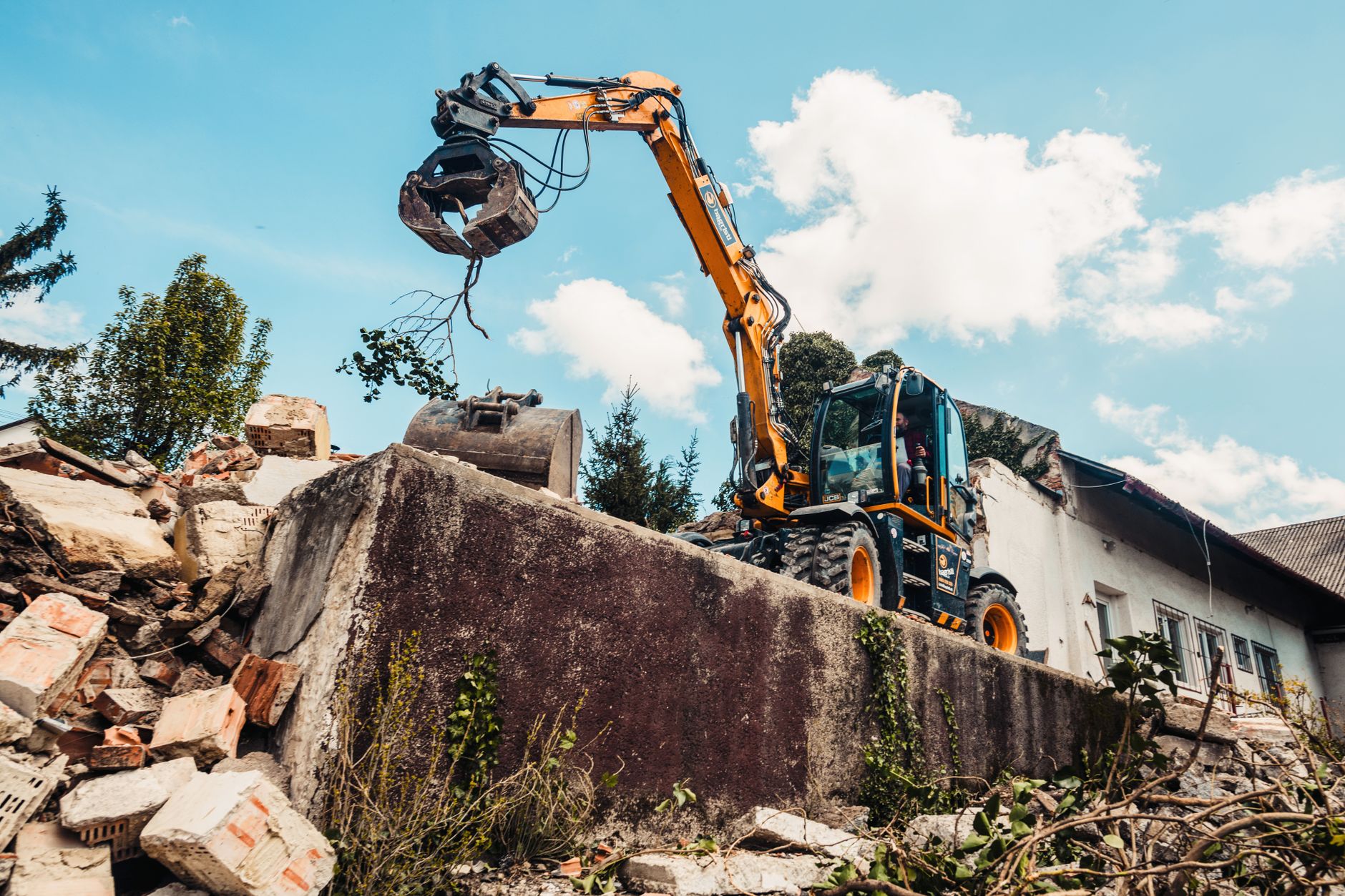 A bulldozer efficiently demolishing an old building, clearing rubble